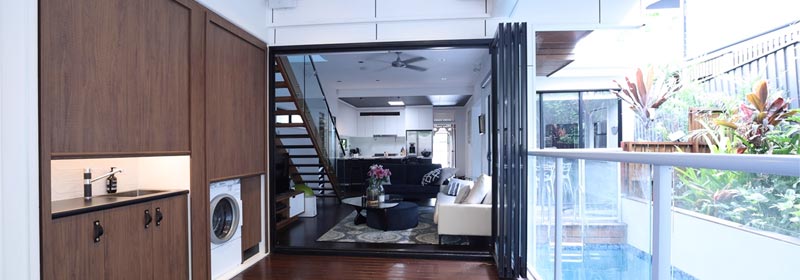 Side-by-side Tambour doors concealing Laundry alcove in a walkway